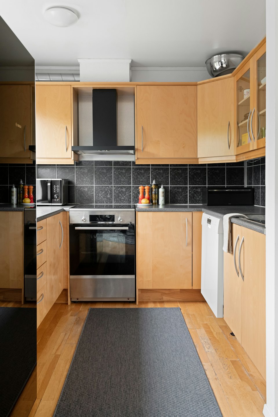 Modern kitchen with wood cabinets and stainless steel appliances.