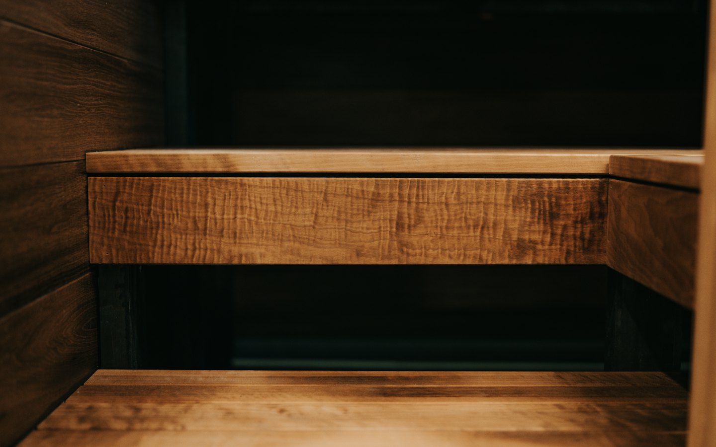 Dark and light wood cabinetry with textured drawer fronts.
